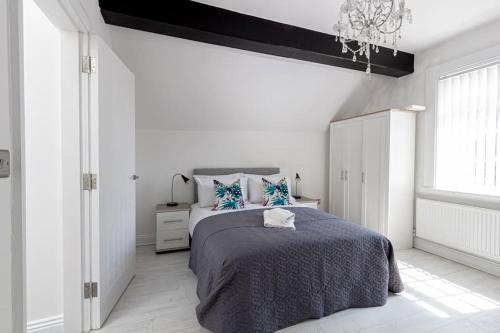 a white bedroom with a bed and a window at Elegant 1BR Apartment, Sleeps up to 4 in Childwall
