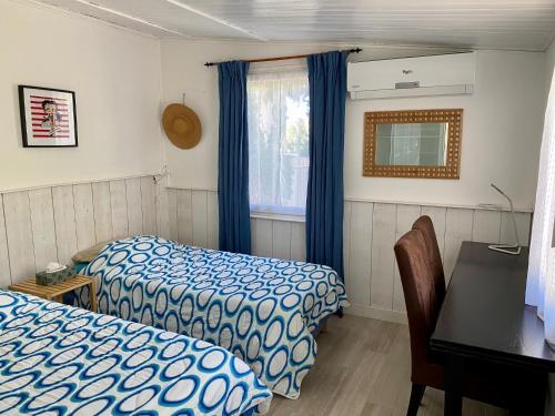 a bedroom with two beds and a desk and a table at Maisonnette à Portissol, plages et Port à pieds! in Sanary-sur-Mer
