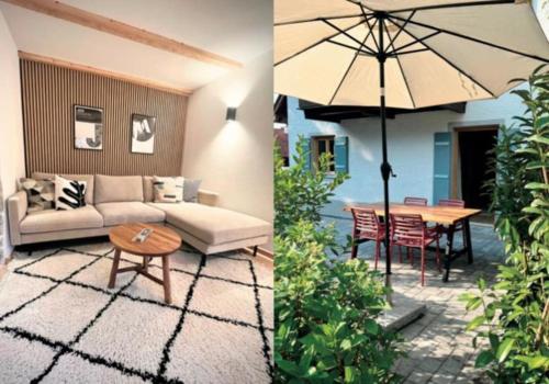 a patio with a couch and a table and an umbrella at Neu! Ferienhaus Moritz & Josie (zur Alleinnutzung) / Eröffnung 01. Juli 2023 in Ohlstadt