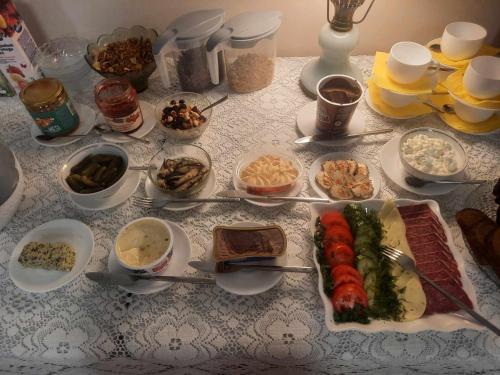 una mesa cubierta con platos y tazones de comida en Aiakeskuse hostel, en Rakvere