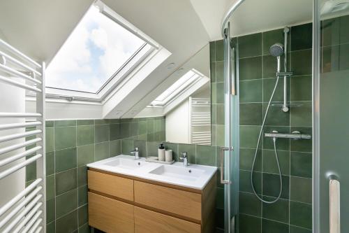 a bathroom with a sink and a shower with a skylight at La Maison Du Verger - 4 chambres aux portes de Rennes in Saint-Jacques-de-la-Lande