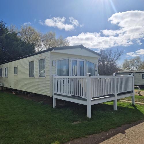 a mobile home with a porch and a white railing at Modern 6 Berth Static Caravan, Hunstanton in Hunstanton