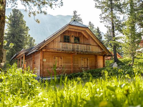a wooden cabin with a balcony in the woods at Alpin-Hütten auf der Turracherhöhe - Haus Fuchs by S4Y in Turracher Hohe