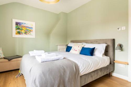 sypialnia z dużym łóżkiem z ręcznikami w obiekcie Nina's Cottage - Southwold w mieście Southwold