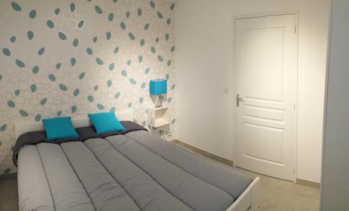 une chambre avec un grand lit avec des oreillers bleus dans l'établissement Bas de Villa T3 55m2 piscine, à Six-Fours-les-Plages