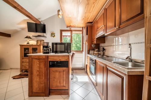 a kitchen with wooden cabinets and a sink at Au Rêve Savoyard 7 - 4 personnes in Morillon