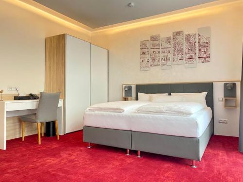 um quarto com uma cama, uma secretária e uma cadeira em Hotel am Waldkasino em Erfurt