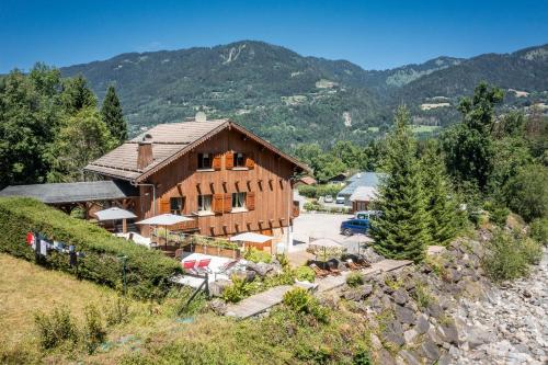 a house on a hill with mountains in the background at Au Rêve Savoyard 7 - 4 personnes in Morillon