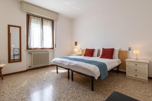 een slaapkamer met een bed met rode kussens en een spiegel bij CASA LOMBARDI in Malcesine