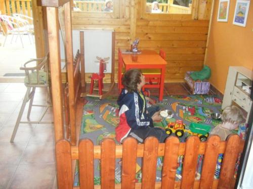 two children playing with a toy train in a crib at Penzion Diana in Kunžak