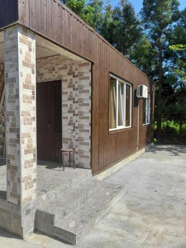 um edifício de tijolos com uma porta e uma janela em Mariam's Cottage em Kobuleti