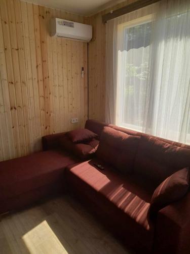 uma sala de estar com um sofá e uma janela em Mariam's Cottage em Kobuleti