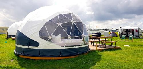 uma tenda cúpula com uma mesa num campo em Lodge Camp Harlesiel direkt am Wattenmeer em Wittmund