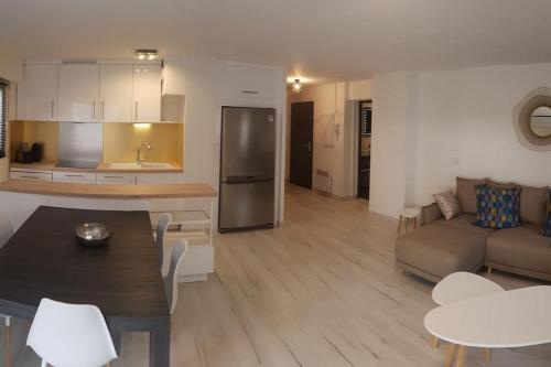 une cuisine et un salon avec une table et un canapé dans l'établissement Duplex Port Frejus 5’ plage et commerces, à Fréjus