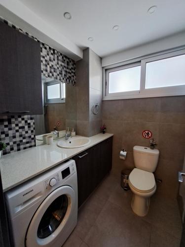 ein Badezimmer mit einer Waschmaschine und einem Waschbecken in der Unterkunft Albert's apartment St Lazarus 402 B - First Floor in Larnaka