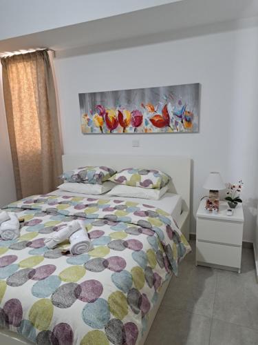 a bedroom with a bed with a colorful comforter at Albert's apartment St Lazarus 402 B - First Floor in Larnaka