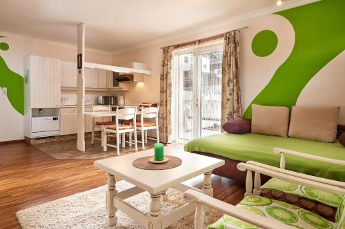- un salon avec un canapé vert et une table dans l'établissement Hotel Garni Tannenhof, à Flachau