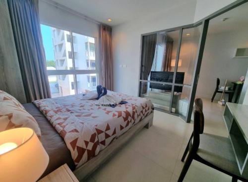 a bedroom with a bed and a large window at Grandblue condominium 301 in Ban Tha Fat