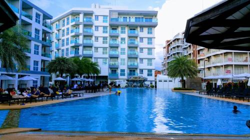 a large swimming pool in front of a building at Grandblue condominium 301 in Ban Tha Fat