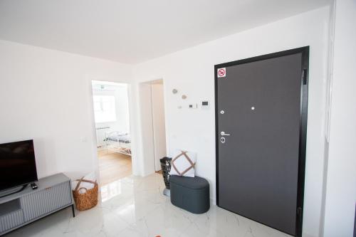 a large black door in a room with a television at Apartmani Kac in Karlovac