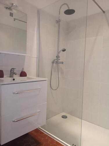 une salle de bain blanche avec une douche et un lavabo dans l'établissement ROSEVA - T2 vue mer - climatisation, à Canet