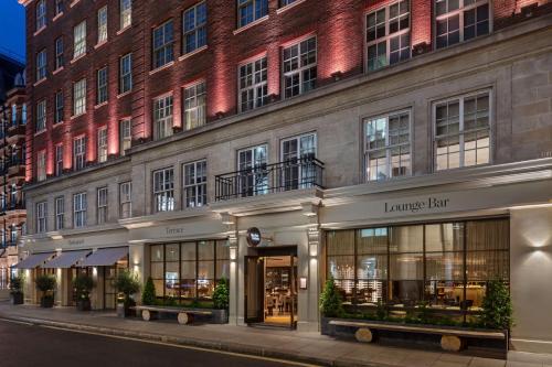 uma fachada de um edifício com um grande edifício de tijolos em The May Fair, A Radisson Collection Hotel, Mayfair London em Londres