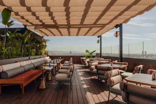 a restaurant with tables and chairs on a balcony at Nobu Hotel Barcelona in Barcelona