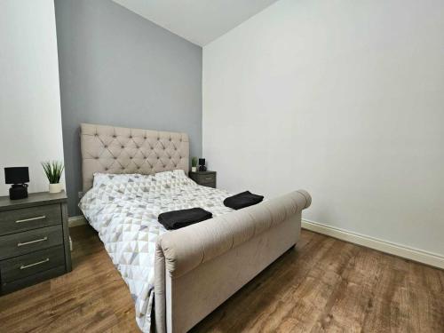 um quarto branco com uma cama e uma cómoda e uma cama sidx sidx em Bee Accommodations Backways em Leicester
