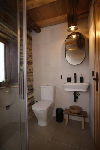 a bathroom with a toilet and a sink at Lar da cima in Folgoso