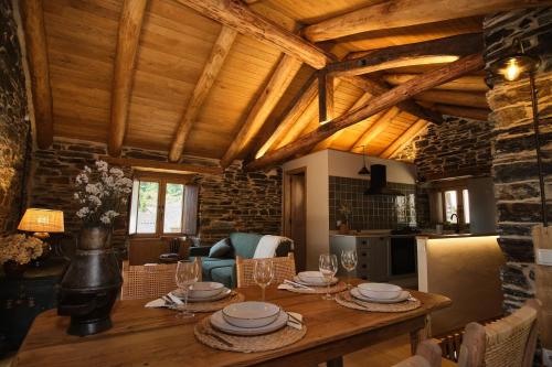a kitchen and dining room with a wooden table and chairs at Lar da cima in Folgoso