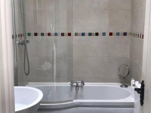 a bathroom with a shower and a tub and a sink at 3 Quay Cottage Killala. Luxury Sea-Front Cottage in Killala