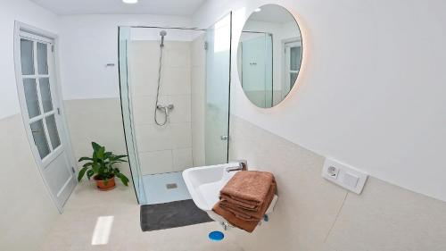 La salle de bains est pourvue d'une douche, d'un lavabo et d'un miroir. dans l'établissement Apartamento, Arena, Primera linea Mar, sea views, à Playa Honda