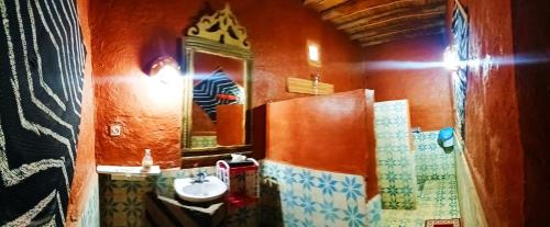 a bathroom with a sink and a mirror at Auberge Camping Ocean des dunes in Merzouga