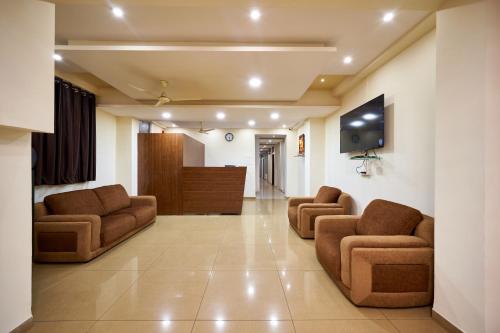 a waiting room with two chairs and a tv at Hotel Ranjan Deluxe in Kolhapur