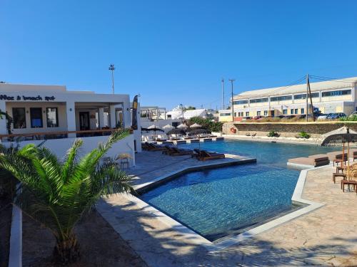 a swimming pool next to a building with a resort at Naxos Village hotel in Naxos Chora