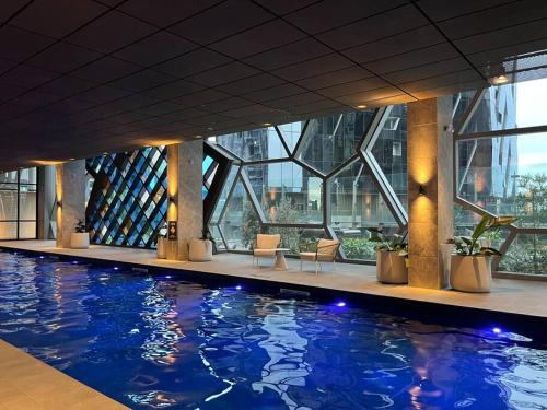duży basen w budynku z oknami w obiekcie Style City Apartment Living ! w Melbourne