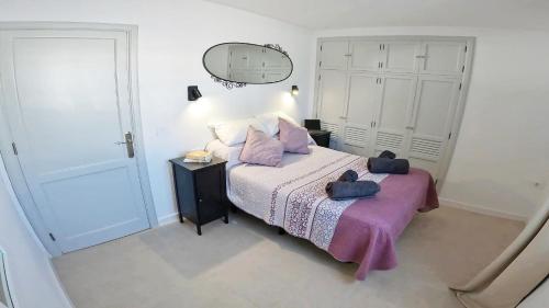 a bedroom with a bed with purple sheets and a mirror at Apartamento, Arena, Primera linea Mar, sea views in Playa Honda