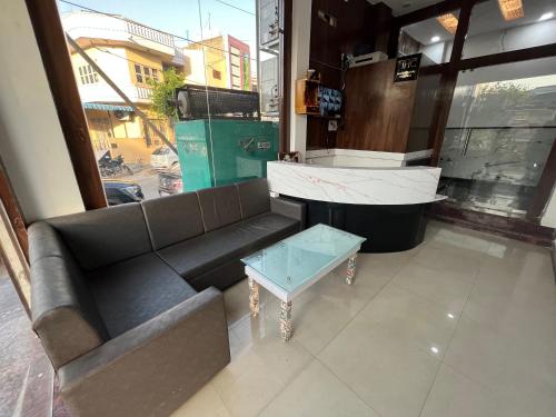 uma sala de estar com um sofá e um piano em Hotel Shree A unit of THC Group em Kota