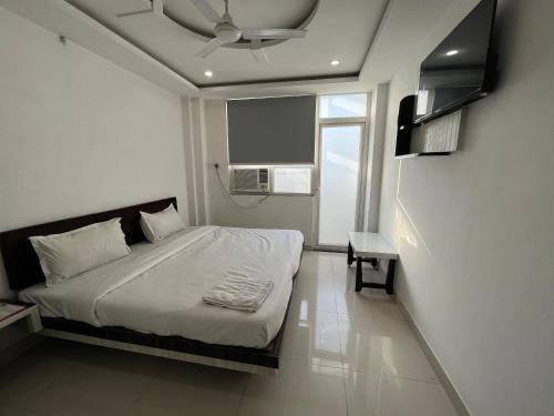 1 dormitorio con 1 cama y ventilador de techo en Hotel Shree A unit of THC Group en Kota