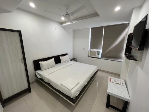 a small bedroom with a bed and a television at Hotel Shree A unit of THC Group in Kota