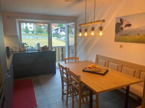 eine Küche und ein Esszimmer mit einem Holztisch und Stühlen in der Unterkunft Apartment Margherita in Sedrun