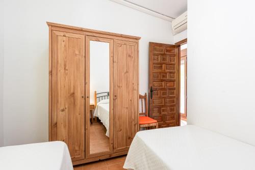 Schlafzimmer mit einer Holztür, die zu einem Bett führt in der Unterkunft The Gardener Cottage in Málaga