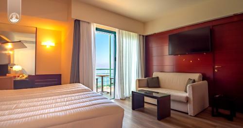 a hotel room with a bed and a chair and a television at Club Hotel Casino Loutraki in Loutraki