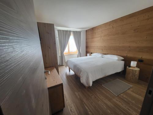 een slaapkamer met een wit bed en een raam bij K2 home in Bormio