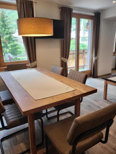 a dining room with a wooden table and chairs at K2 home in Bormio