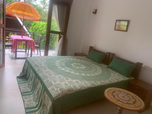 a bedroom with a bed and a balcony with a table at MILLET'S FOOD COMPANY AND COOKING CENTER in Negombo