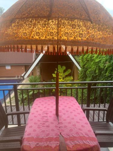 a pink table with an umbrella on a balcony at MILLET'S FOOD COMPANY AND COOKING CENTER in Negombo