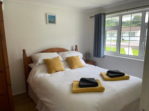 a bedroom with a bed with two towels on it at Bumble Bee Lodge in Liskeard