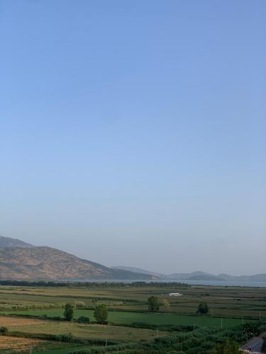 a view of a field with mountains in the background at Panoramic Views of Saranda in Sarandë