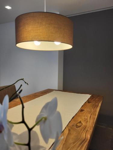 a room with a bed with a lamp and flowers at K2 home in Bormio